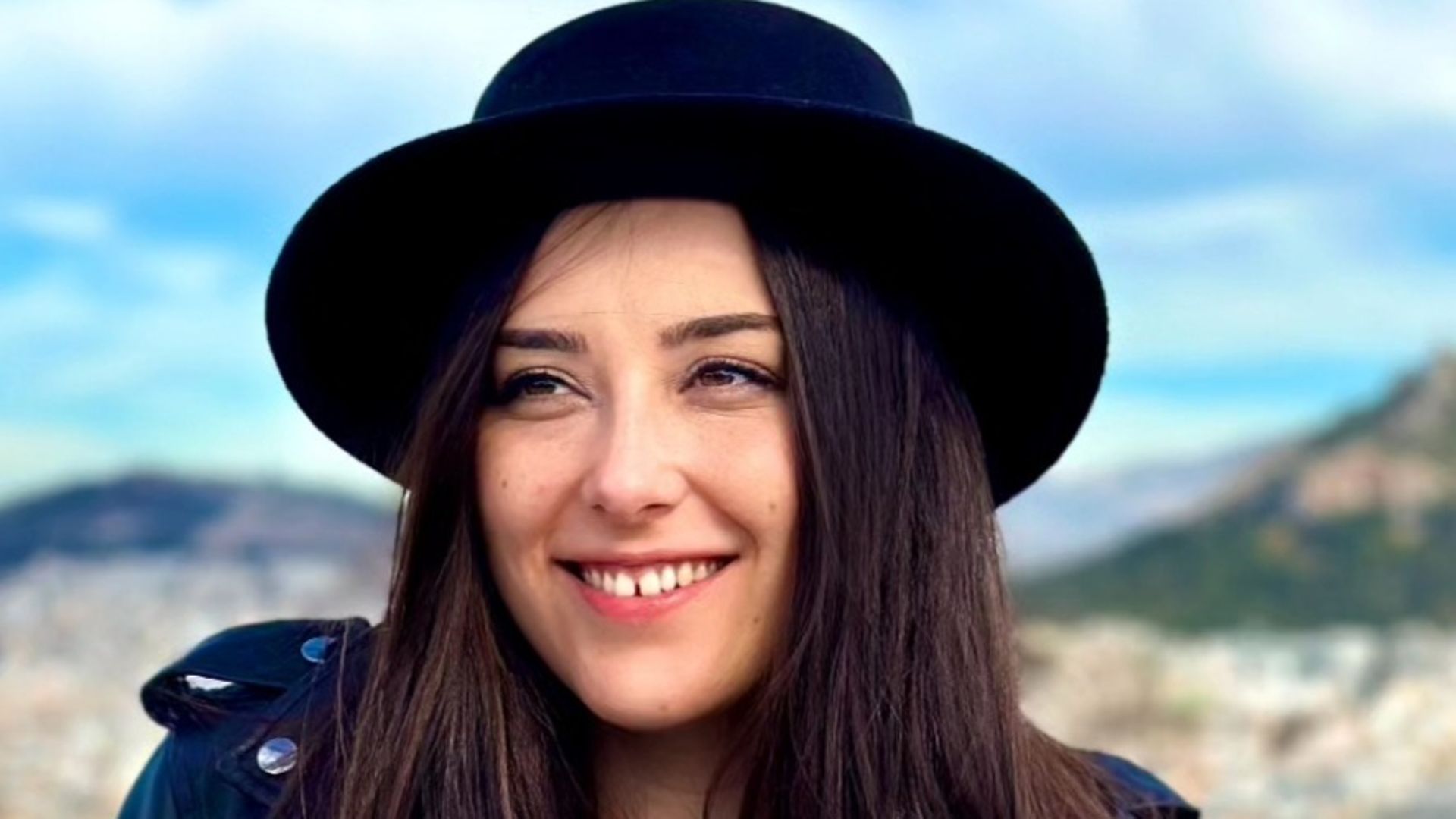 Lachende Mitarbeitenrin mit Hut 