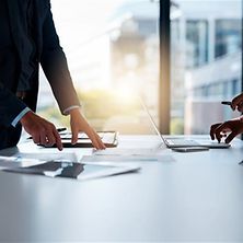 Zwei Mitarbeitende bearbeiten Dokumente an einem Schreibtisch 