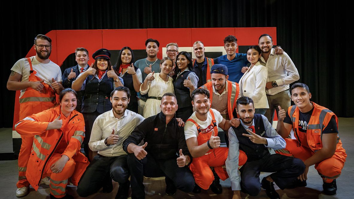 Eine Gruppe junger Menschen in Arbeitskleidung posiert auf einem Event für Ausbildungsberufe mit dem Daumen nach oben
