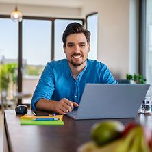 Ein Berater sitzt zuhause und arbeitet am Laptop